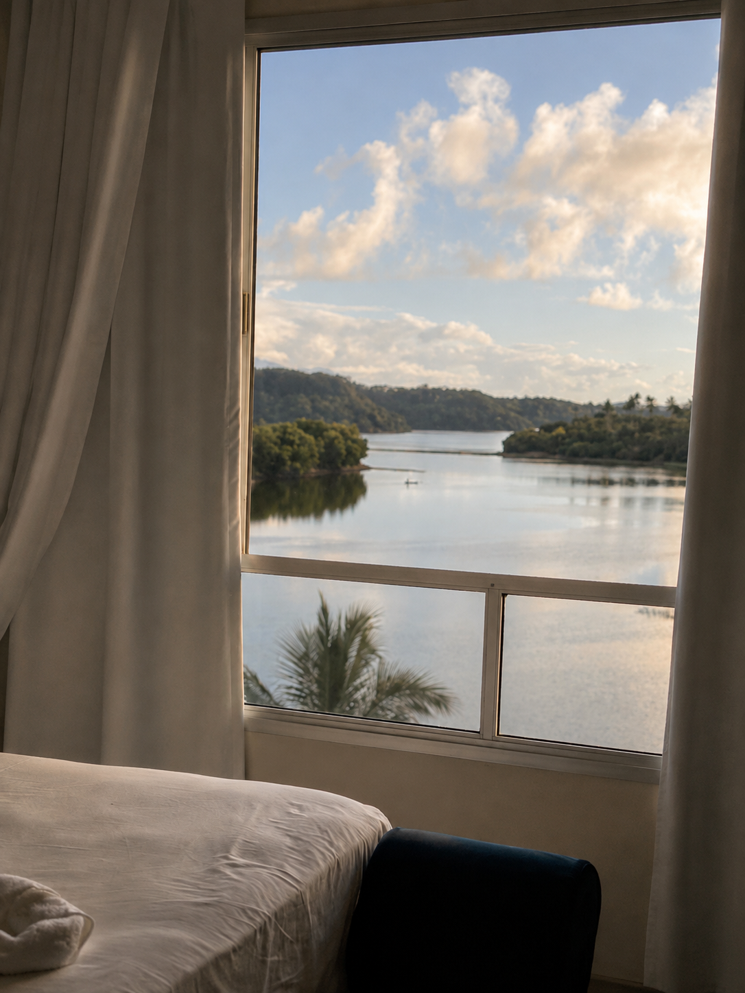 Suíte de design com cortinas brancas e vista direta para a água